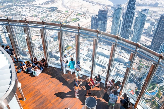 Visitors enjoy panoramic views of Dubai from the observation deck on Levels 124 and 125 of the Burj Khalifa, with city skyscrapers and urban landscape stretching into the distance.