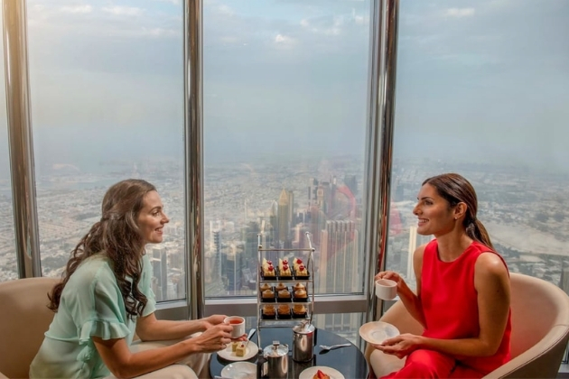 Guests enjoy afternoon tea at The Lounge on Levels 152–154 of the Burj Khalifa, with sweeping views of Dubai through floor-to-ceiling windows.