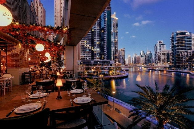 A vibrant view of Dubai Marina with waterfront restaurants offering a variety of international cuisines, attracting food lovers from around the world.