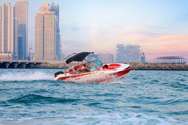 Person performing flyboarding tricks above the water with powerful water jets in Dubai.