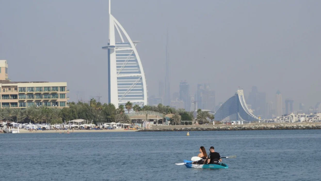 Person enjoying a kayaking ride on the calm waters of Dubai with stunning city skyline views in the background.